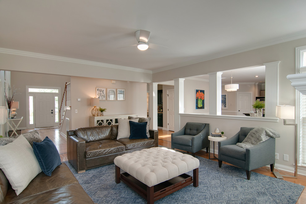 Foto di un soggiorno moderno di medie dimensioni con pareti grigie, pavimento in legno massello medio, camino classico e pavimento marrone