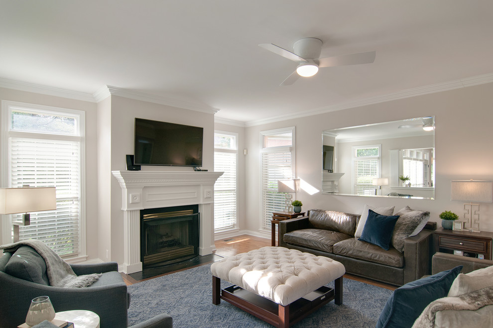 Medium sized modern living room in Nashville with grey walls, medium hardwood flooring, a standard fireplace and brown floors.
