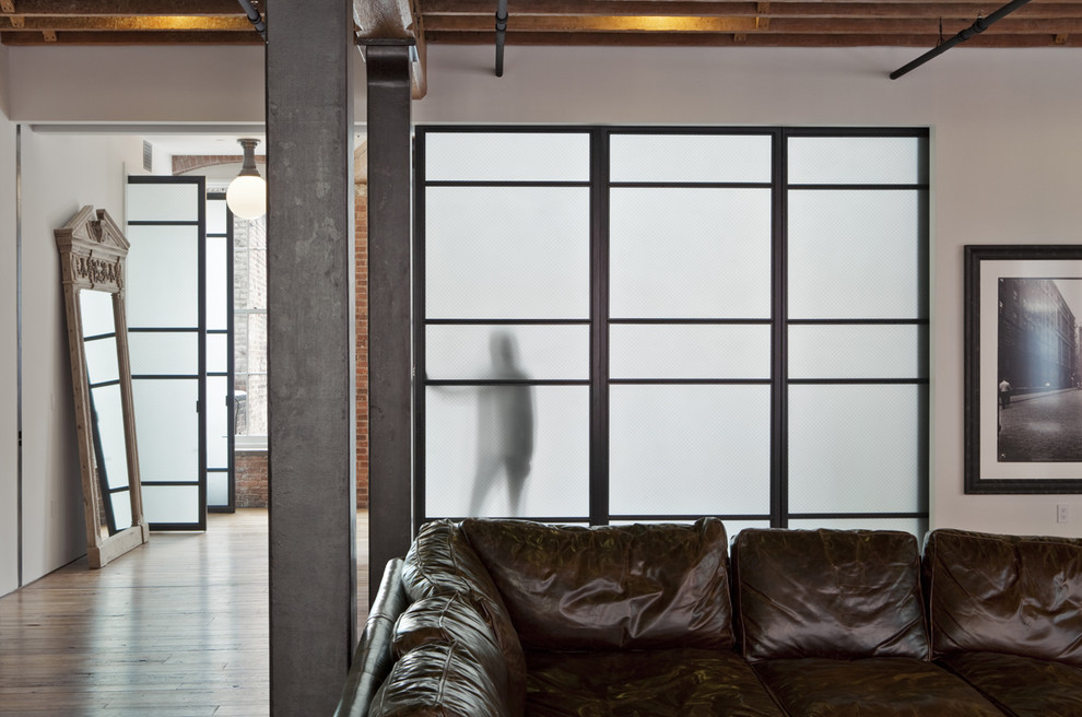 Foto di un grande soggiorno industriale aperto con pareti bianche e pavimento in legno massello medio
