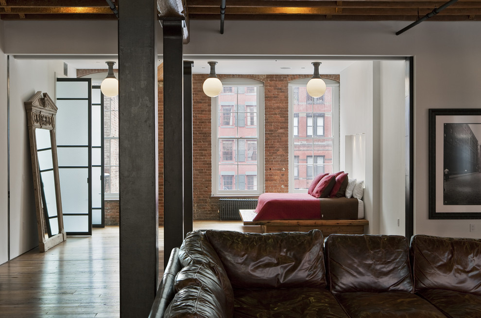 Großes, Offenes Industrial Wohnzimmer mit weißer Wandfarbe und braunem Holzboden in New York