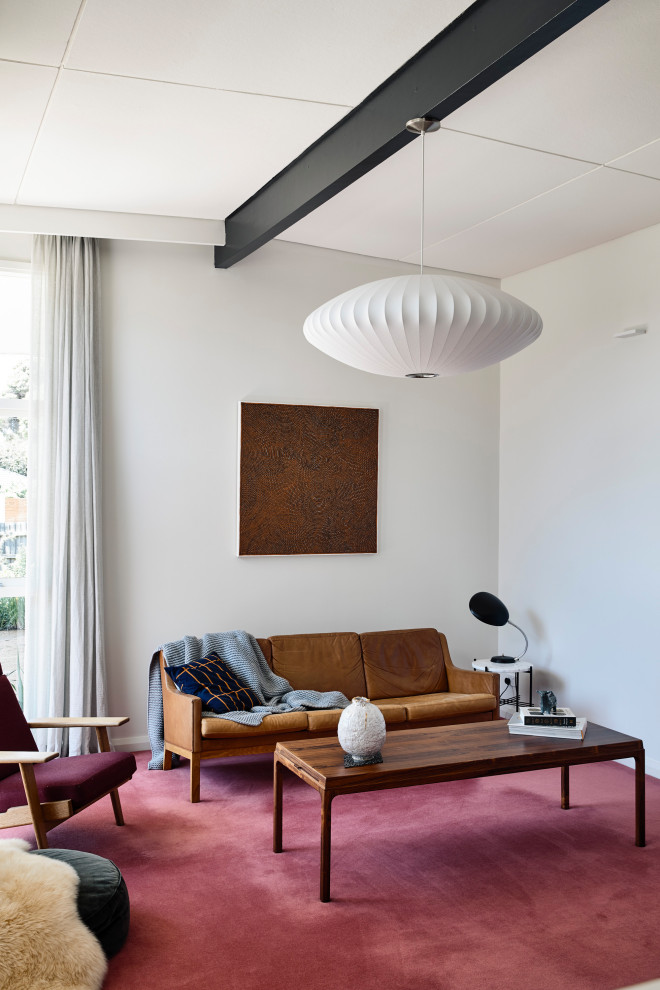 Стильный дизайн: гостиная комната в стиле ретро с белыми стенами, ковровым покрытием, красным полом, балками на потолке, сводчатым потолком и коричневым диваном - последний тренд