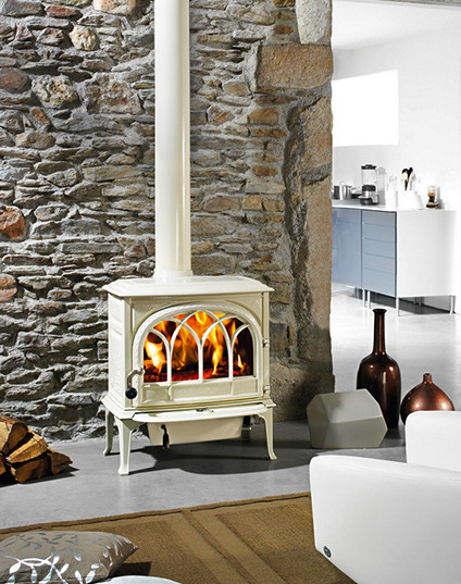 デンバーにある中くらいなラスティックスタイルのおしゃれなリビング (薪ストーブ、金属の暖炉まわり、白い壁、無垢フローリング) の写真
