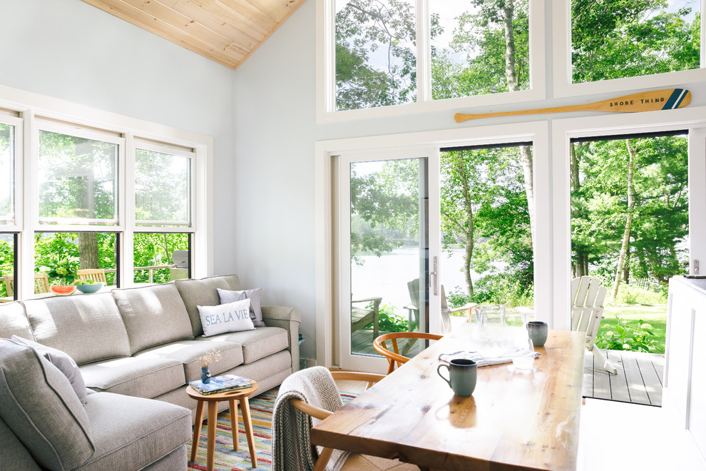 Kleines, Fernseherloses, Offenes Modernes Wohnzimmer ohne Kamin mit blauer Wandfarbe und hellem Holzboden in Portland Maine