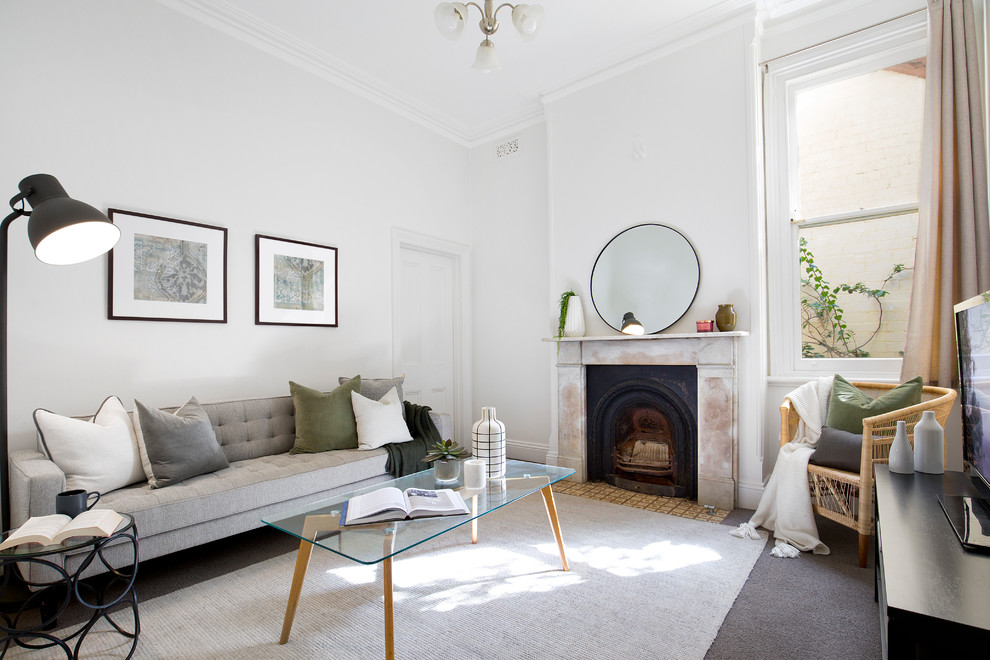 Immagine di un soggiorno rustico chiuso con pareti bianche, moquette, camino classico, TV autoportante e pavimento grigio