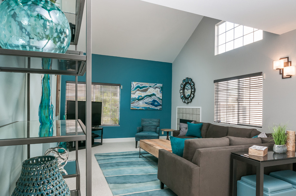 Idée de décoration pour un salon design de taille moyenne et ouvert avec un mur bleu, moquette, une cheminée standard, un manteau de cheminée en carrelage et un téléviseur indépendant.