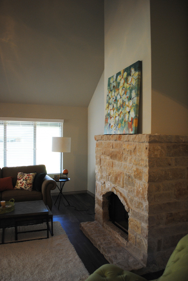 Ejemplo de salón para visitas abierto bohemio de tamaño medio con paredes beige, todas las chimeneas, marco de chimenea de piedra y televisor colgado en la pared