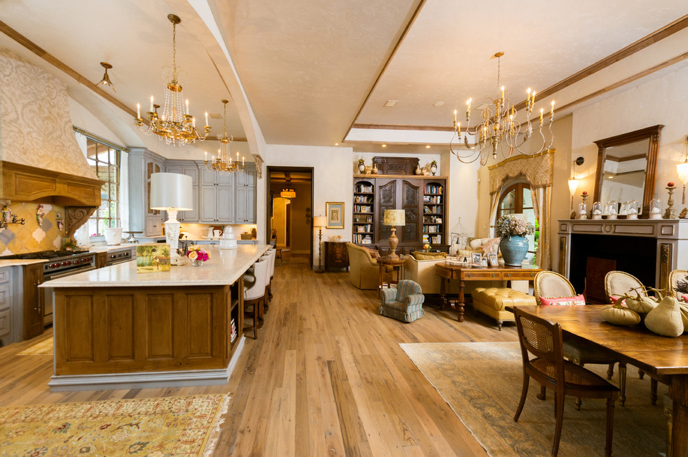Offenes Wohnzimmer mit beiger Wandfarbe, braunem Holzboden und beigem Boden in Houston