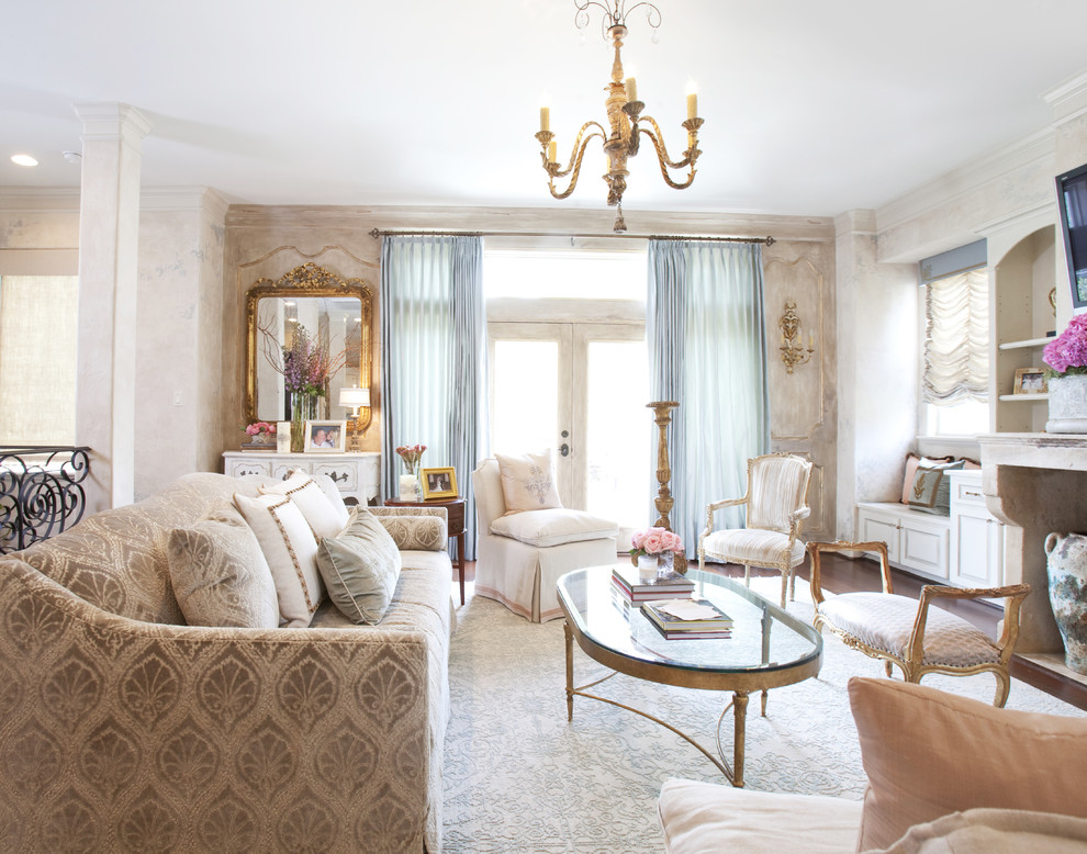 Immagine di un soggiorno classico con pareti beige, camino classico e TV a parete