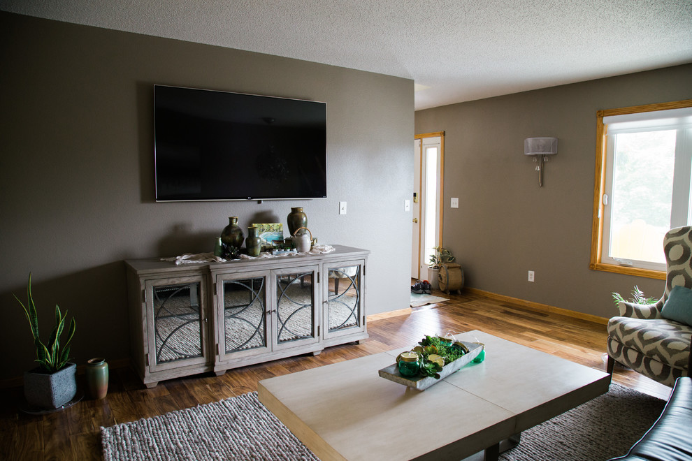 Свежая идея для дизайна: изолированная гостиная комната среднего размера в стиле кантри с серыми стенами, паркетным полом среднего тона, телевизором на стене и коричневым полом без камина - отличное фото интерьера
