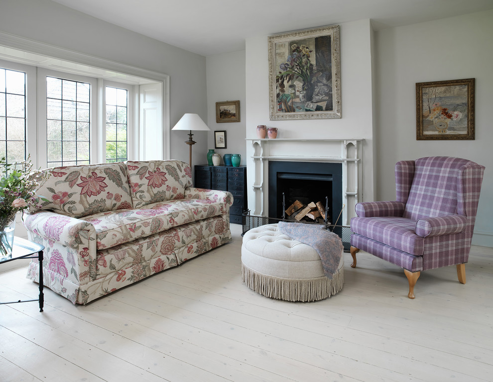 Landhaus Wohnzimmer mit weißer Wandfarbe, gebeiztem Holzboden und Kaminumrandung aus Holz in Oxfordshire