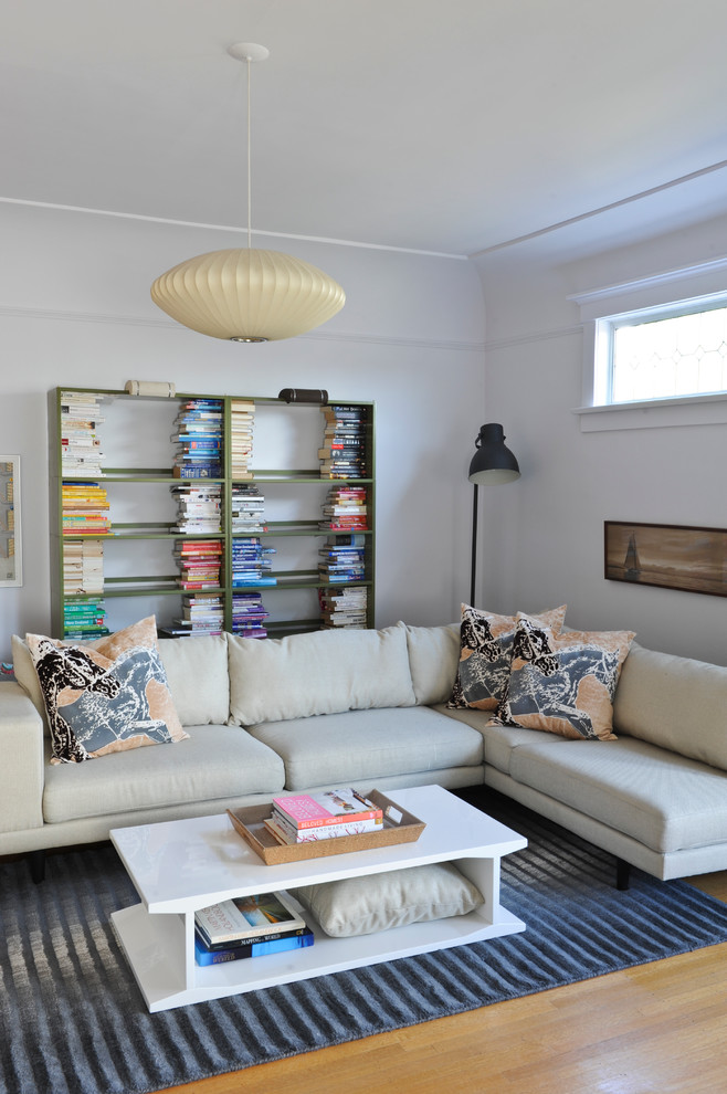 Modernes Wohnzimmer mit weißer Wandfarbe und braunem Holzboden in Vancouver