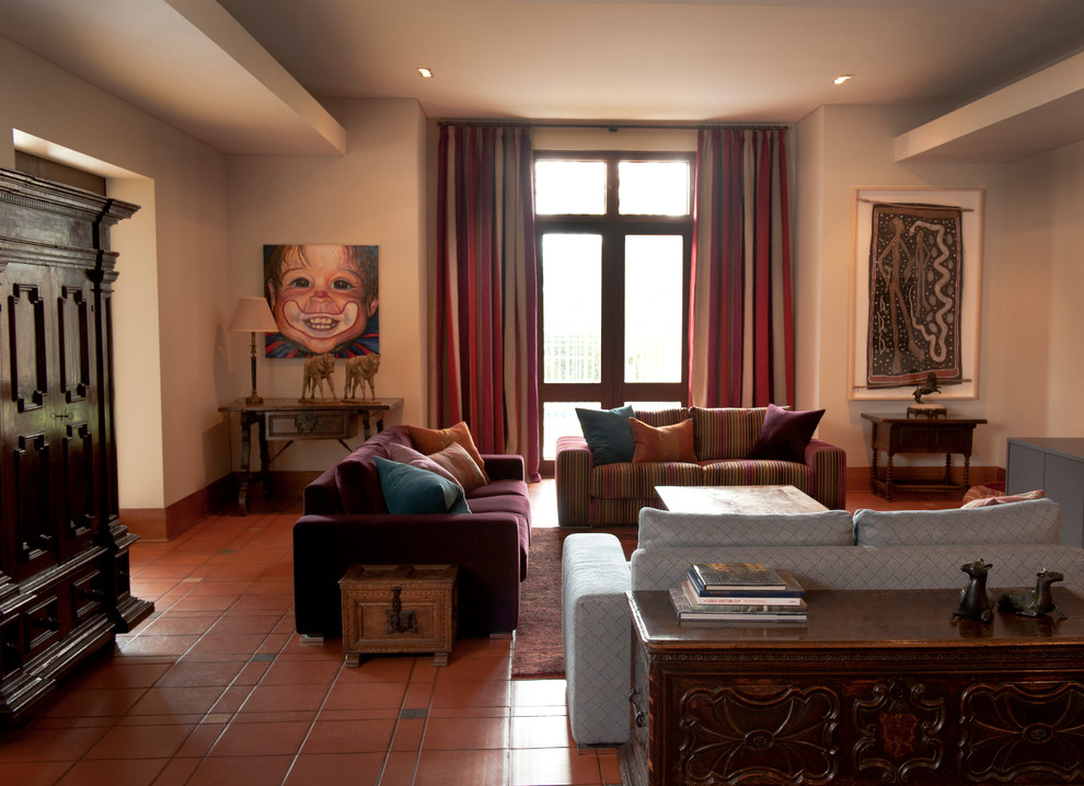 На фото: большая парадная, изолированная гостиная комната в стиле фьюжн с полом из терракотовой плитки с