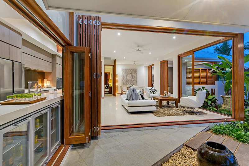 Foto di un soggiorno tropicale di medie dimensioni e aperto con pareti bianche e pavimento in gres porcellanato