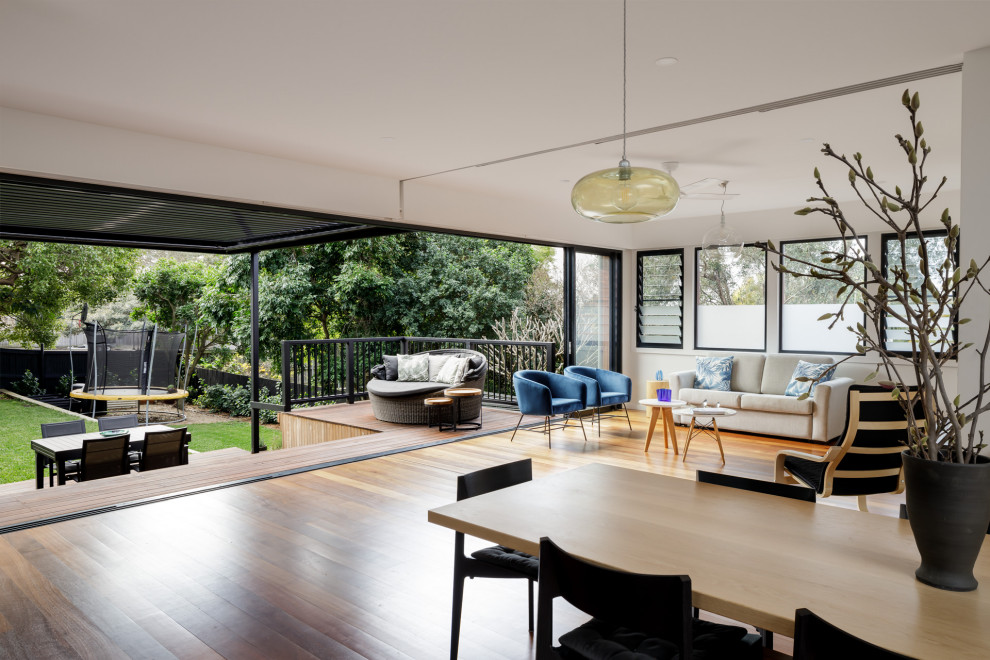 Mittelgroßes, Abgetrenntes Modernes Wohnzimmer mit weißer Wandfarbe, hellem Holzboden, TV-Wand, braunem Boden und Wandpaneelen in Sydney