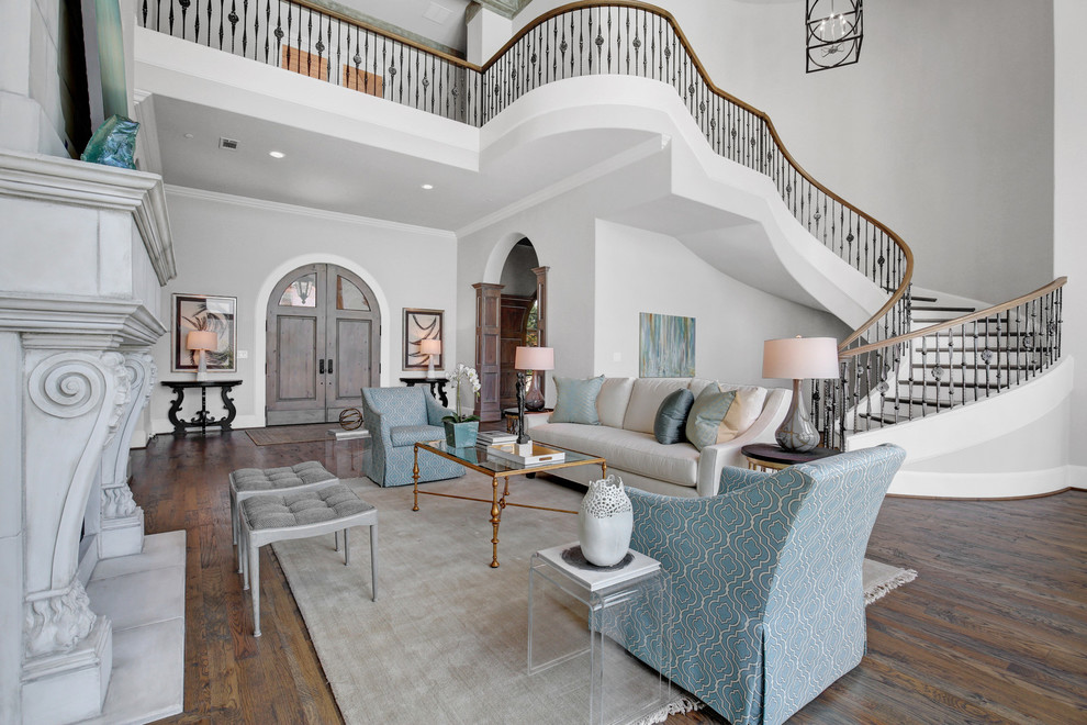 Großes, Repräsentatives, Offenes Mediterranes Wohnzimmer mit grauer Wandfarbe, braunem Holzboden, Kamin und Kaminumrandung aus Stein in Dallas