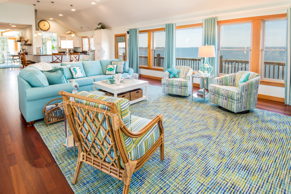 Inspiration for a large coastal open plan living room in Other with blue walls, medium hardwood flooring, a corner fireplace, a stone fireplace surround, a wall mounted tv and brown floors.