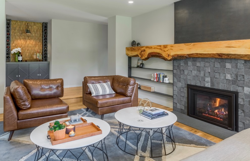 Photo of a medium sized traditional enclosed living room in Seattle with a home bar, grey walls, medium hardwood flooring, a standard fireplace, a stone fireplace surround and brown floors.