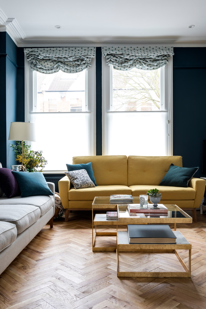 Источник вдохновения для домашнего уюта: открытая гостиная комната в стиле неоклассика (современная классика) с синими стенами, паркетным полом среднего тона, бежевым полом и горчичным диваном