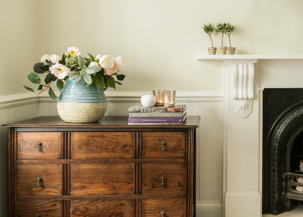 This is an example of a small traditional living room in London with green walls and dark hardwood flooring.