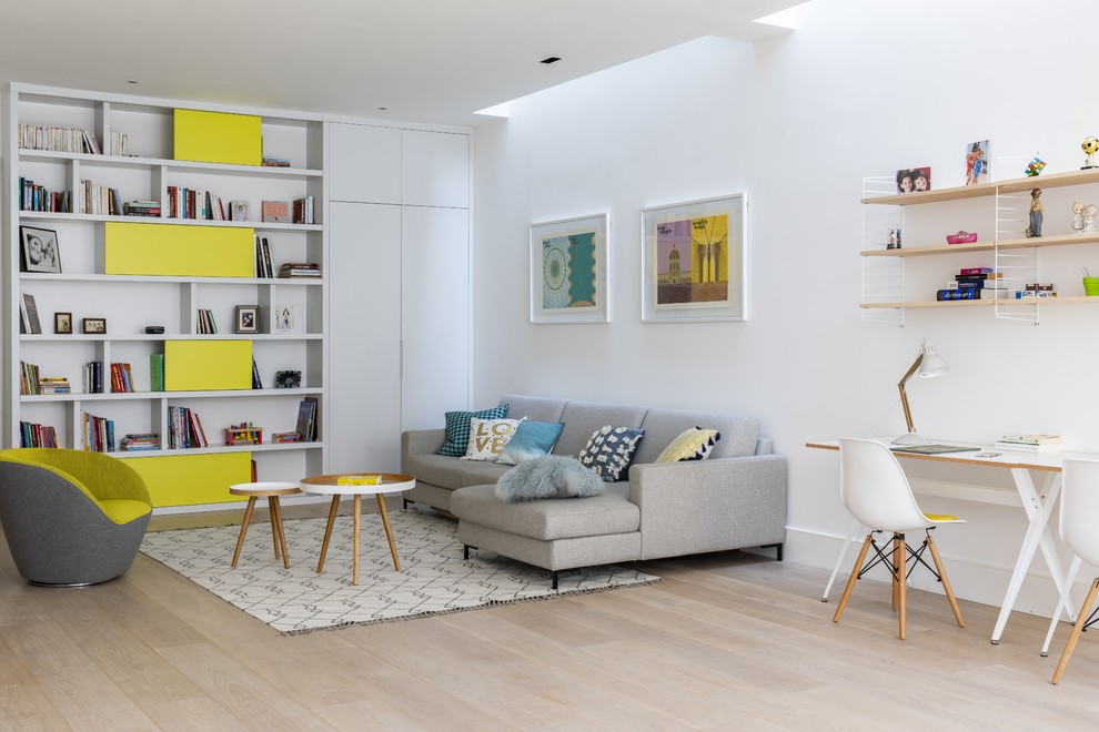 This is an example of a contemporary living room in London with white walls, light hardwood flooring, no fireplace, beige floors and a reading nook.