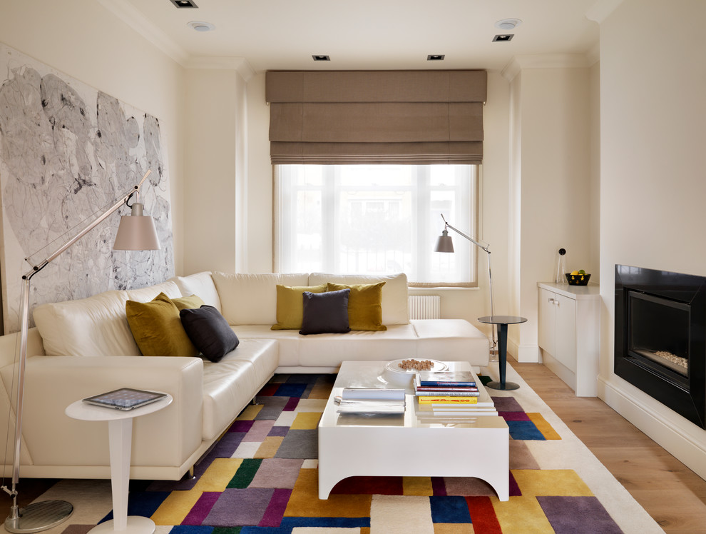 Großes, Abgetrenntes Modernes Wohnzimmer mit beiger Wandfarbe, braunem Holzboden, Gaskamin und Kaminumrandung aus Stein in London