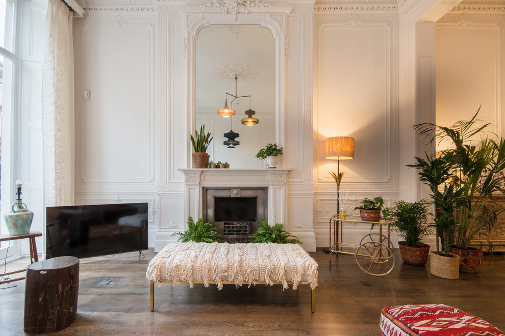 ロンドンにあるラグジュアリーな広いシャビーシック調のおしゃれなLDK (白い壁、淡色無垢フローリング、標準型暖炉、漆喰の暖炉まわり、据え置き型テレビ、ベージュの床) の写真