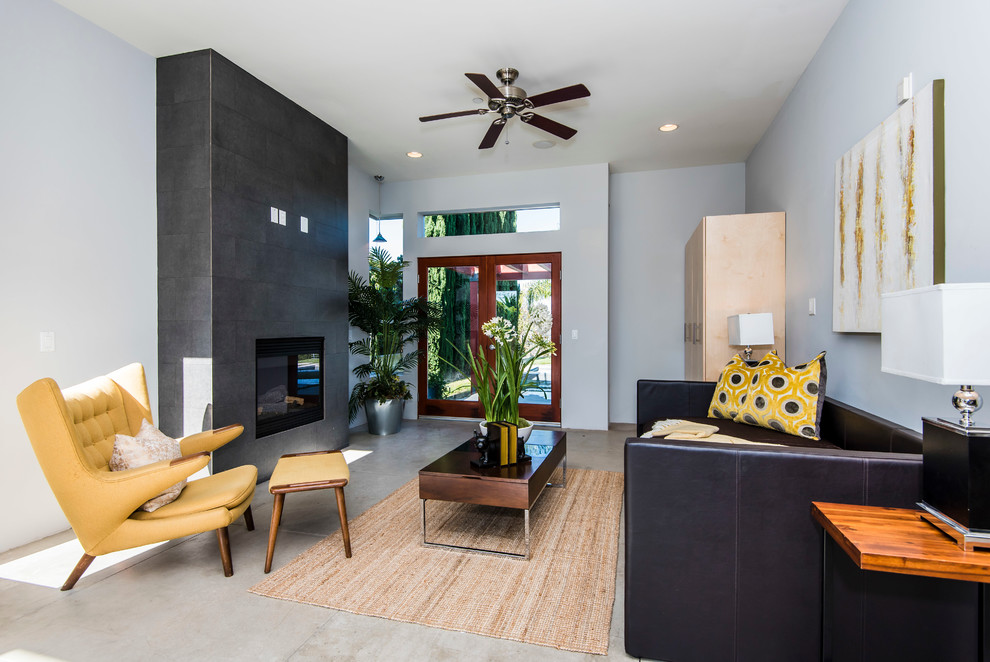 Repräsentatives, Abgetrenntes Modernes Wohnzimmer mit blauer Wandfarbe, Betonboden, Gaskamin und gefliester Kaminumrandung in Los Angeles