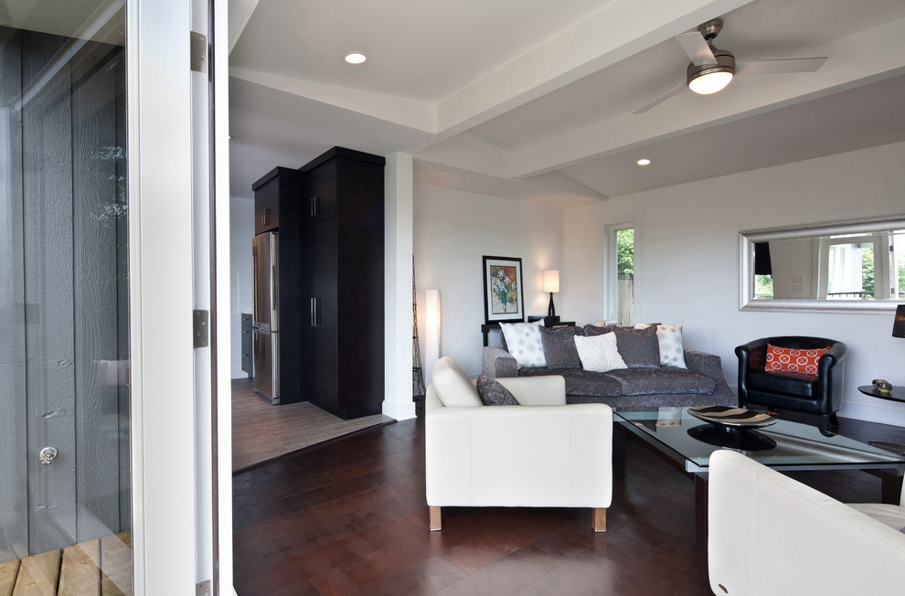 Mittelgroßes, Offenes Klassisches Wohnzimmer mit weißer Wandfarbe, dunklem Holzboden, Kamin, Kaminumrandung aus Metall und TV-Wand in Vancouver
