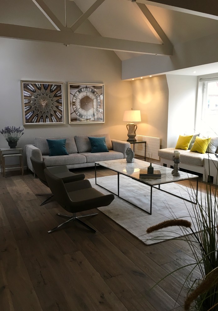 Cette photo montre un salon tendance de taille moyenne avec un mur gris, parquet foncé et un sol marron.