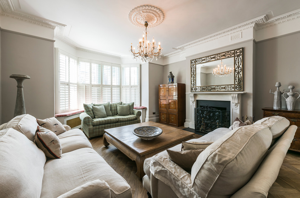 Photo of a large classic living room in London with light hardwood flooring and a standard fireplace.
