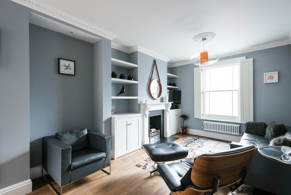 Réalisation d'un très grand salon minimaliste avec un mur bleu, un sol en bois brun et une cheminée standard.