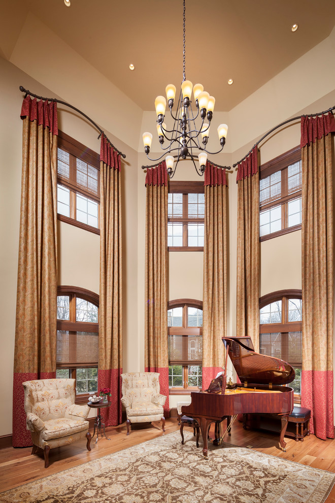 Foto de salón con rincón musical tipo loft tradicional grande sin chimenea y televisor con paredes beige y suelo de madera en tonos medios