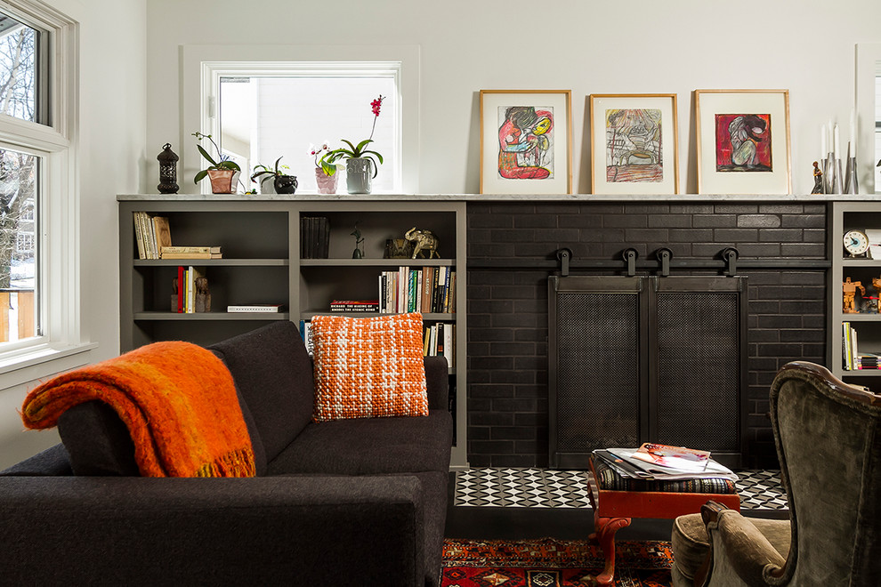 Kleines Eklektisches Wohnzimmer mit weißer Wandfarbe, dunklem Holzboden, Kamin, Kaminumrandung aus Backstein und braunem Boden in Minneapolis