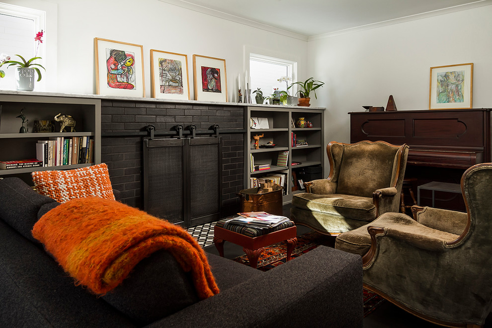 Immagine di un piccolo soggiorno eclettico con pareti bianche, parquet scuro, camino classico, cornice del camino in mattoni e pavimento marrone