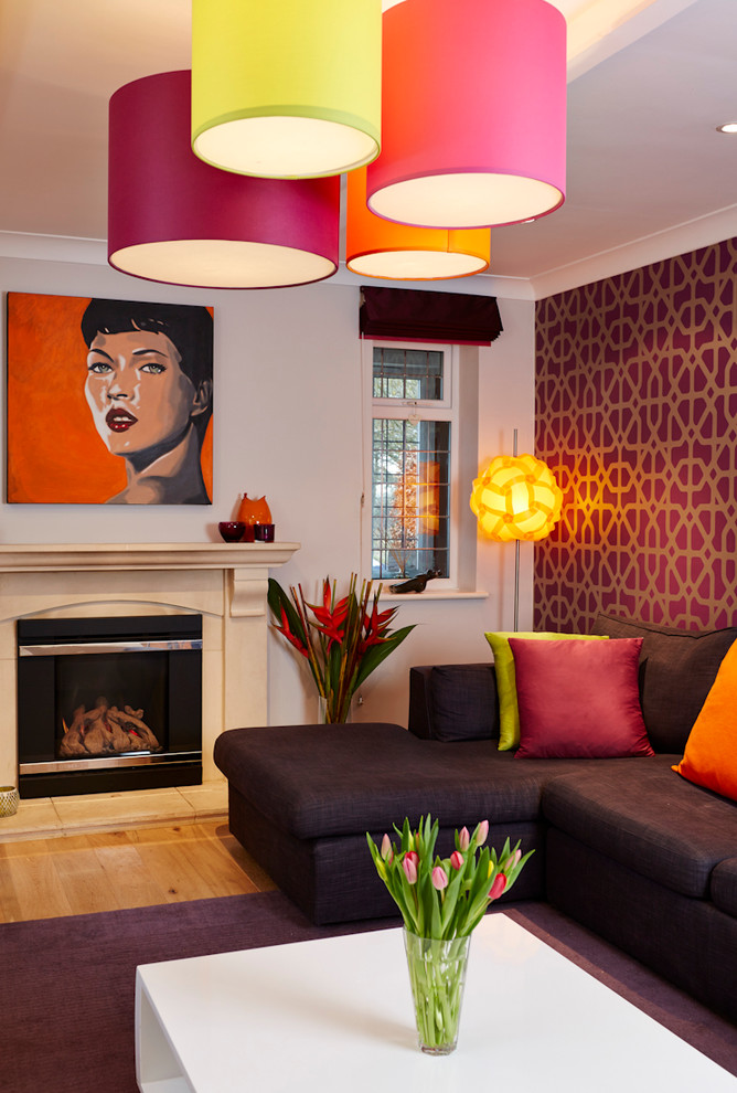 Immagine di un soggiorno design con pareti viola, parquet chiaro e cornice del camino in pietra