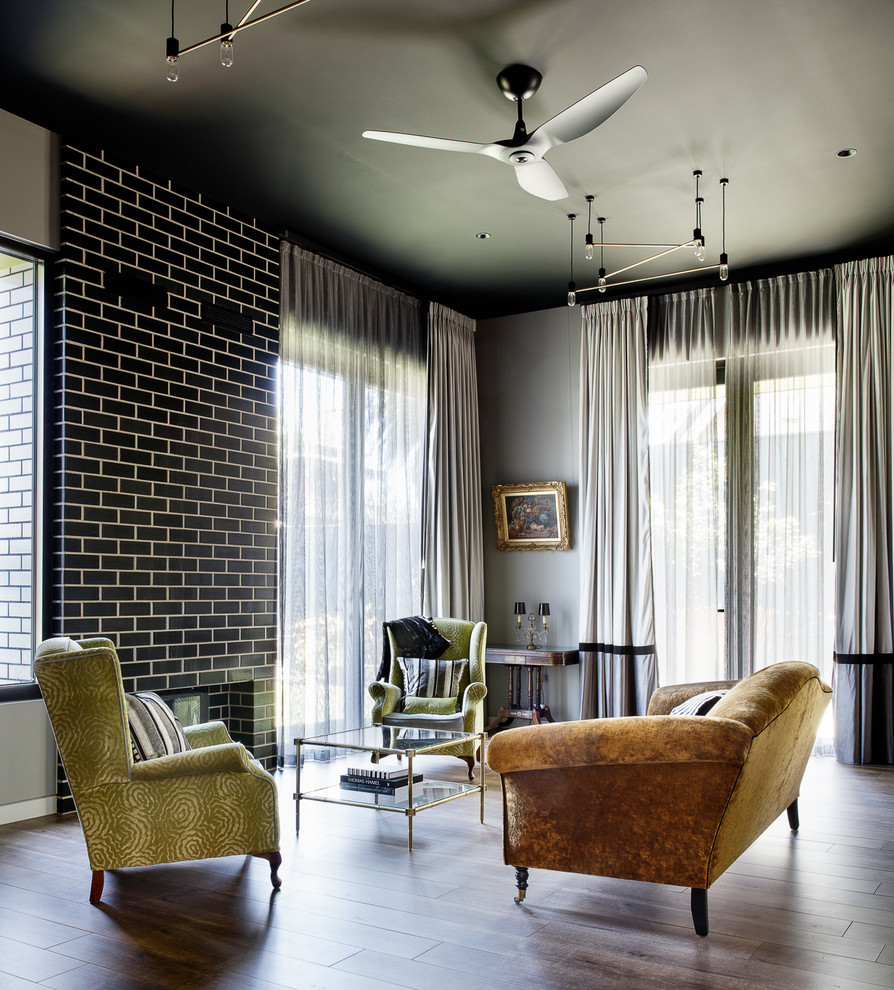 This is an example of a large bohemian open plan living room in Melbourne with grey walls, medium hardwood flooring, a standard fireplace, a tiled fireplace surround, no tv and brown floors.