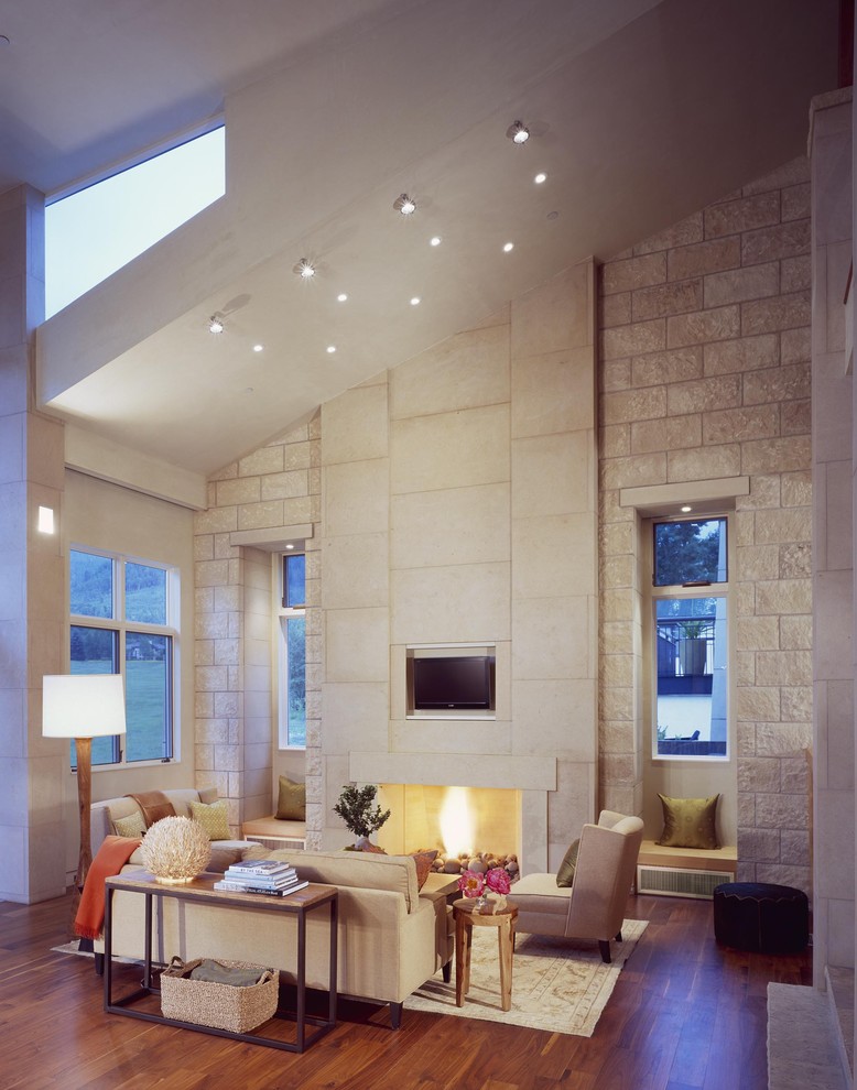 Foto di un soggiorno design con pareti beige, camino classico e parete attrezzata