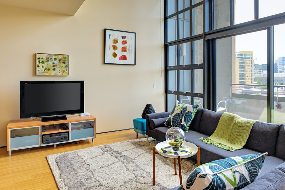 Immagine di un soggiorno minimalista con pareti beige e TV autoportante