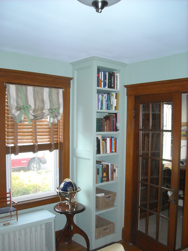 Idéer för att renovera ett litet vintage vardagsrum, med ett bibliotek, gröna väggar och mörkt trägolv