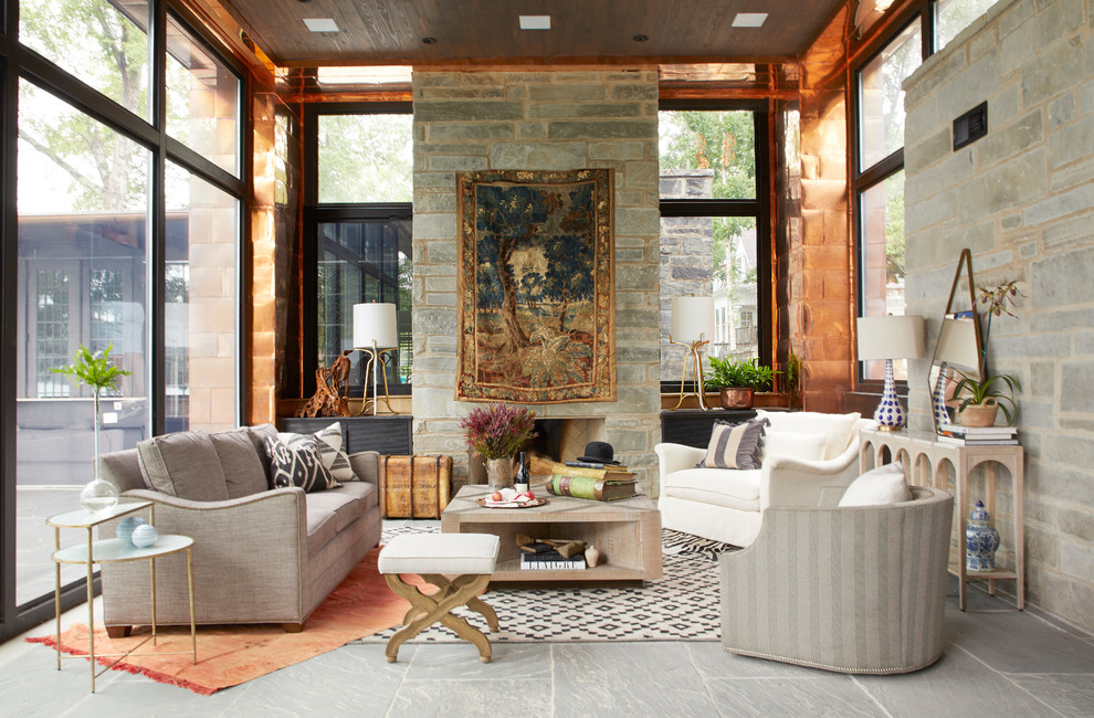 Foto di un soggiorno bohémian con sala formale, pareti grigie, camino classico, cornice del camino in pietra, nessuna TV, pavimento grigio e tappeto
