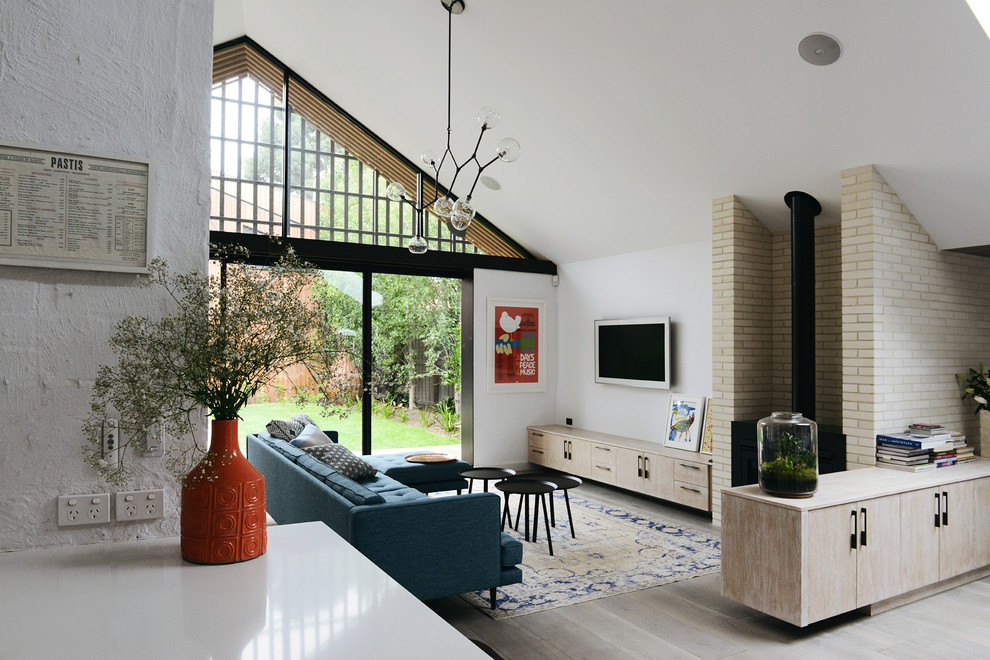 Идея дизайна: гостиная комната в скандинавском стиле с белыми стенами, светлым паркетным полом и фасадом камина из кирпича