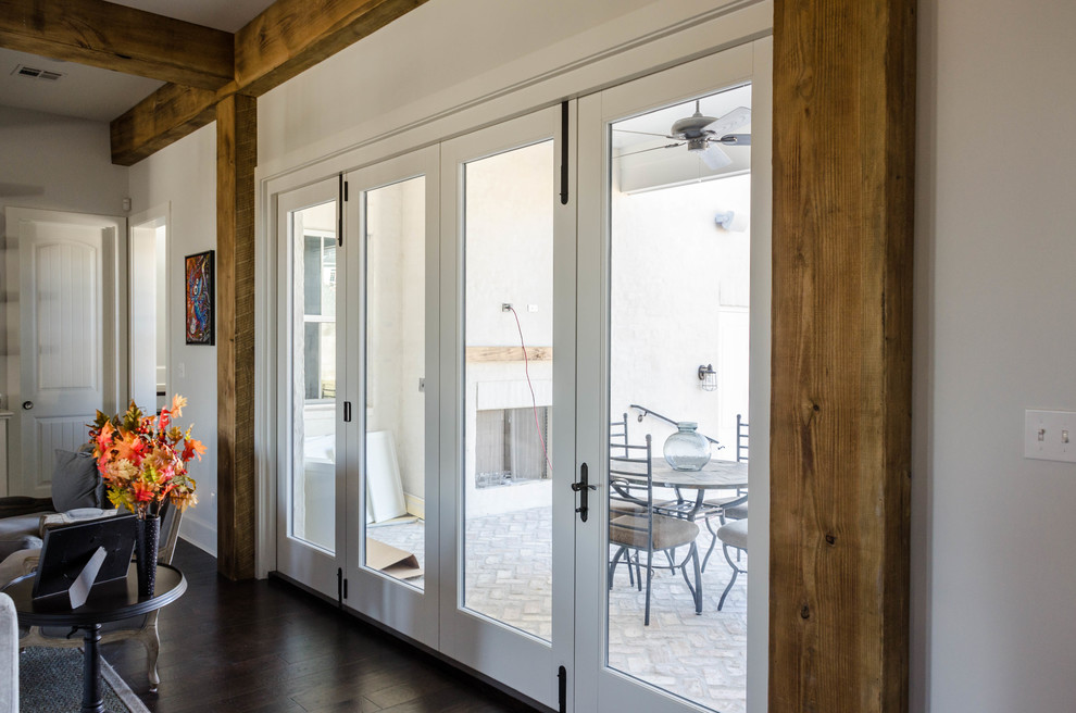 Diseño de salón abierto clásico de tamaño medio sin chimenea y televisor con paredes blancas y suelo de madera oscura