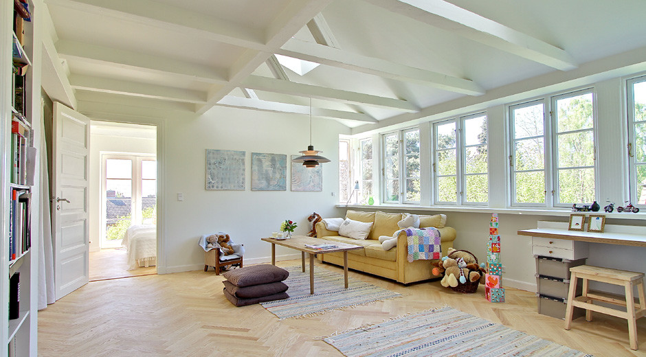 Example of a large danish light wood floor living room design in Other with white walls and no fireplace