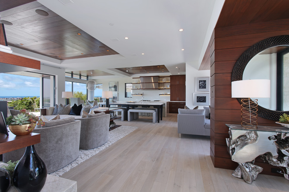 Example of a large trendy open concept light wood floor and brown floor living room design in Orange County with white walls