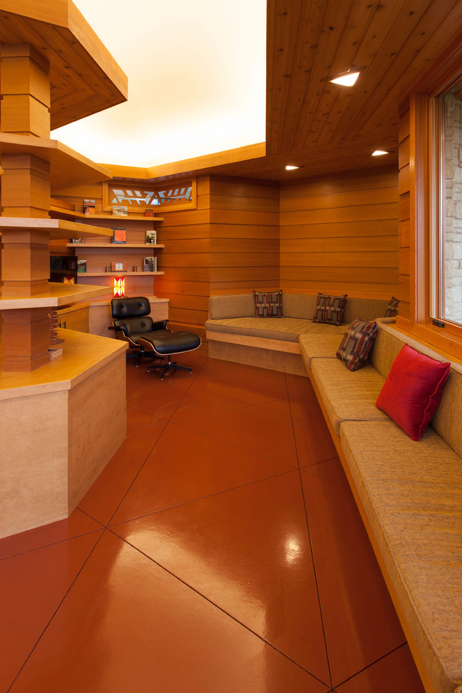 Источник вдохновения для домашнего уюта: изолированная гостиная комната в стиле ретро с с книжными шкафами и полками и коричневыми стенами