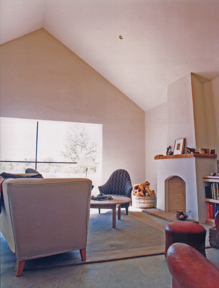 Idée de décoration pour un salon design de taille moyenne et ouvert avec un mur beige, sol en béton ciré, une cheminée standard et aucun téléviseur.