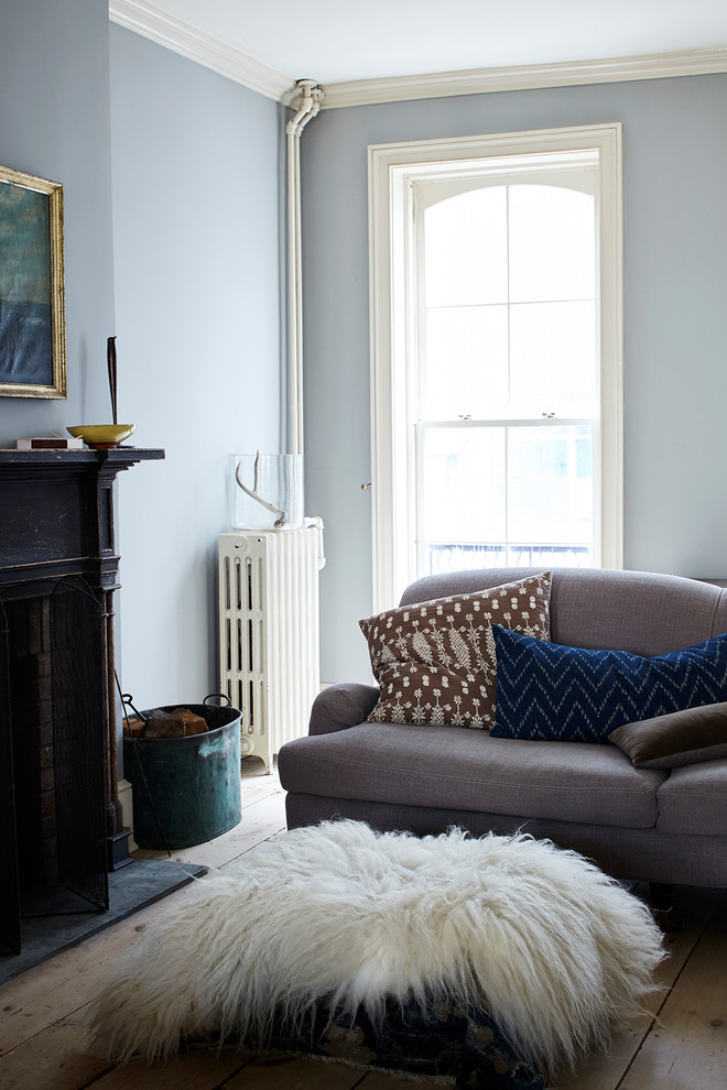 Esempio di un piccolo soggiorno chiuso con pareti blu, parquet chiaro, camino classico, cornice del camino in legno, nessuna TV e pavimento beige