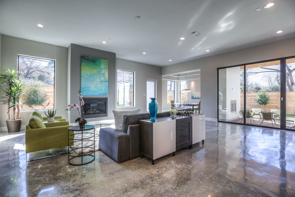 Großes, Offenes Modernes Wohnzimmer mit grauer Wandfarbe, Betonboden, Kamin und verputzter Kaminumrandung in Houston