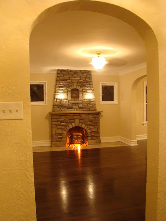 Immagine di un piccolo soggiorno classico con pareti bianche, camino classico, cornice del camino in pietra, parquet scuro e pavimento marrone