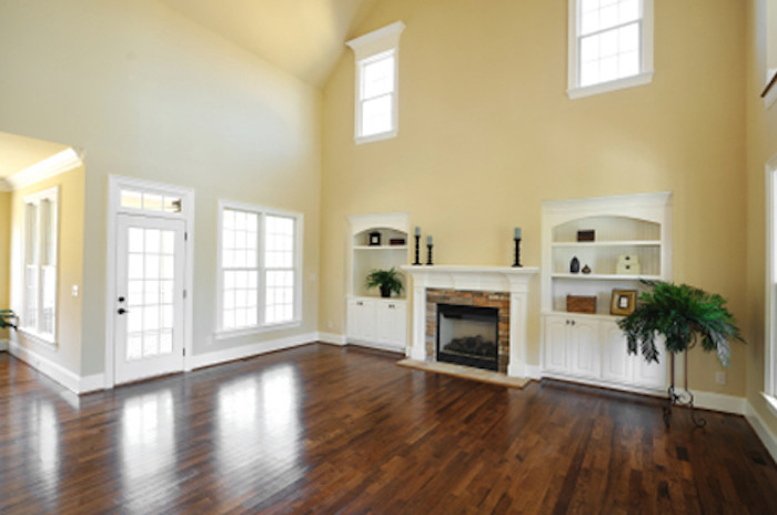 Inspiration for a large timeless formal and open concept dark wood floor living room remodel in Kansas City with yellow walls, a standard fireplace, a brick fireplace and no tv